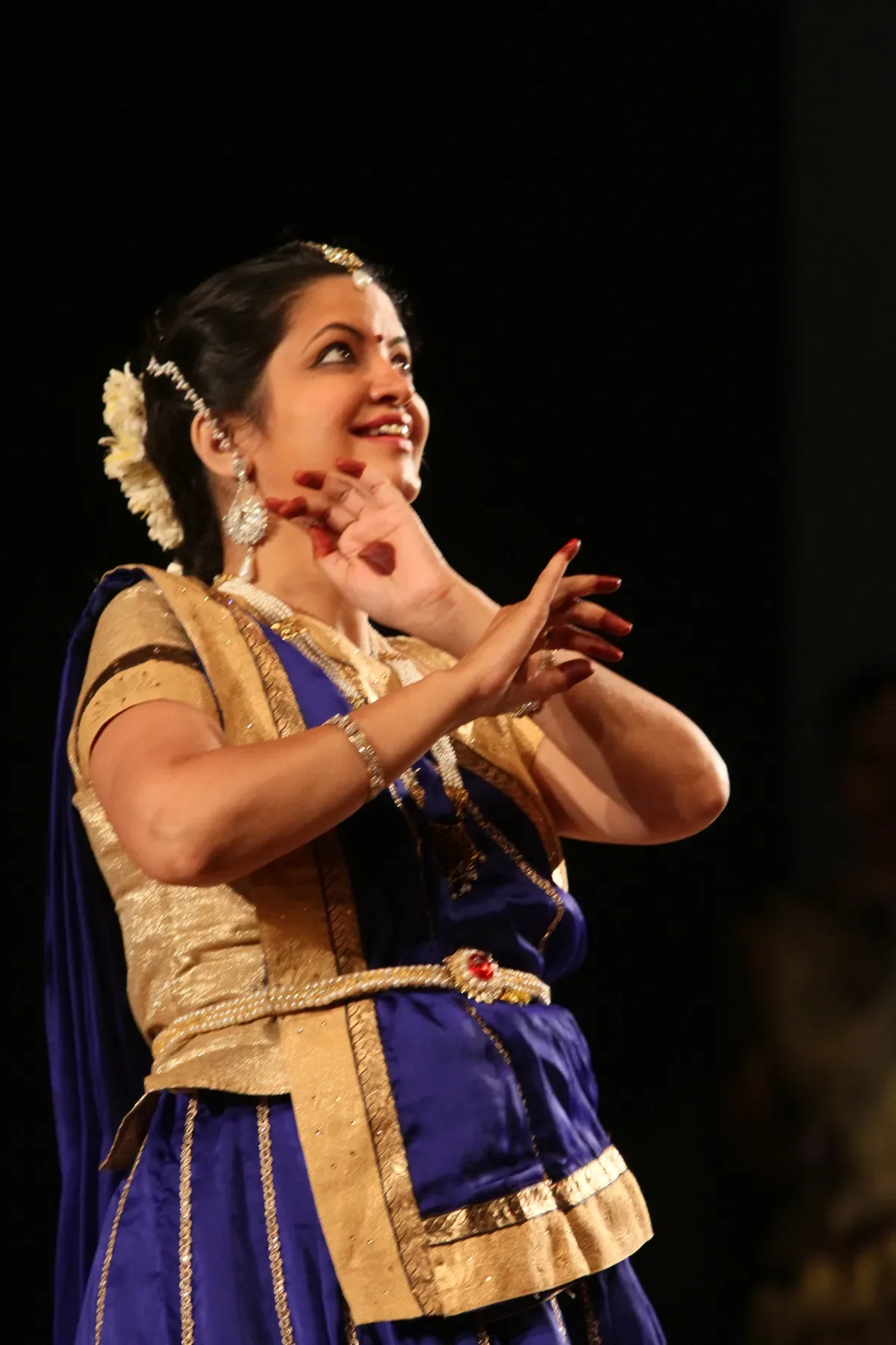 Guru Archana Patwardhan performing abhinaya in blue and gold, the expressive face of Kathak